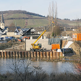 Baustelle der neuen Carl-von-Ehrenwall-Allee Brücke im Stadtteil Ahrweiler mit Blick auf Weinberge im Hintergrund.