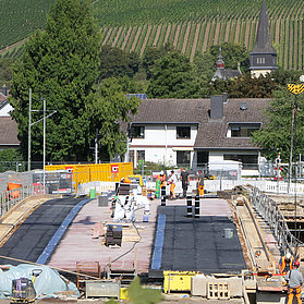Heppinger Brücke im Stadtteil Heppingen im Ahrtal während der Fertigstellung mit Bauarbeitern und Weinbergen im Hintergrund.