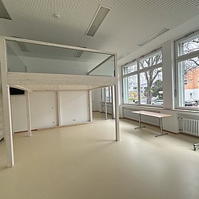 Eine mit Glas verkleidete Empore steht inmitten eines Raumes.