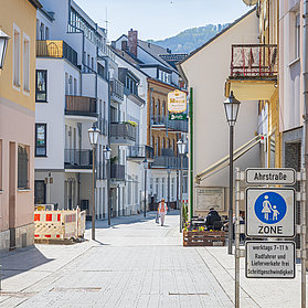Frau läuft bei Sonnenschein durch die fertiggestellte Fußgängerzone.