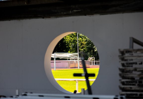 Blick durch eine runde Öffnung auf das noch im Bau befindliche Apollinarisstadion im Stadtteil Bad Neuenahr.