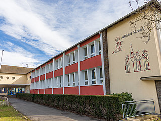 Aloisius-Grundschule im Ortsteil Ahrweiler – moderne Schule im Bau mit großer Fensterfront und Schulmauerzeichnung.
