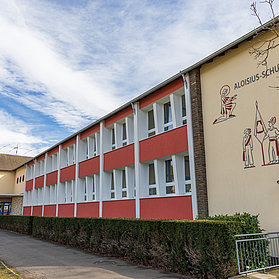Aloisius-Grundschule im Ortsteil Ahrweiler – moderne Schule im Bau mit großer Fensterfront und Schulmauerzeichnung.