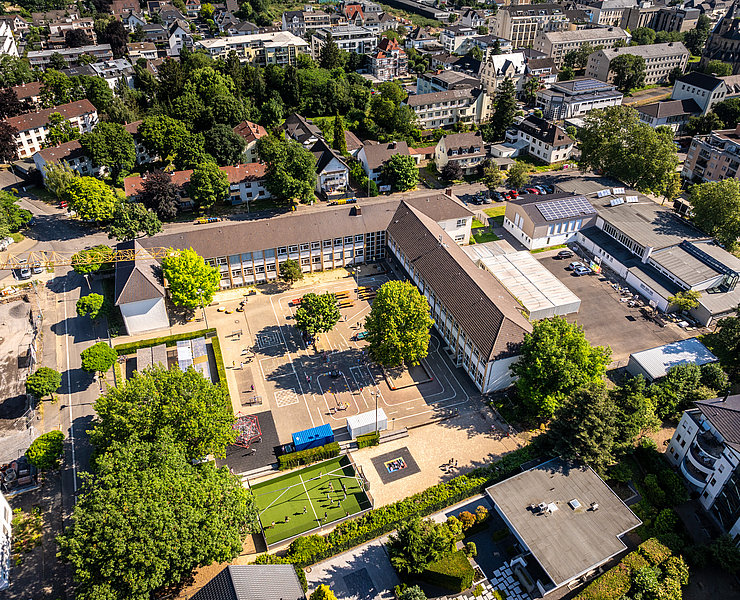 Luftaufnahme der Grundschule Bad Neuenahr im Stadtteil Bad Neuenahr, aktuell im Bau und von viel Grün umgeben.