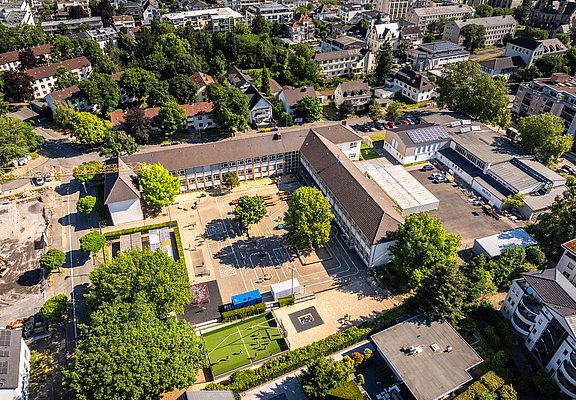 Luftaufnahme der Grundschule Bad Neuenahr im Stadtteil Bad Neuenahr, aktuell im Bau und von viel Grün umgeben.
