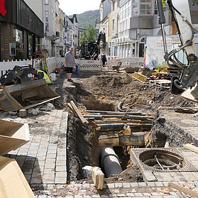 Im Untergrund der Straße wird am Kanal gearbeitet und Rohre werden verlegt