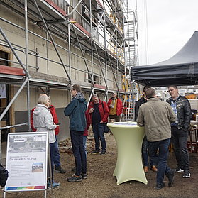 Menschen versammeln sich bei der Baustelle der neuen Kita St. Pius im Stadtteil Bad Neuenahr im Ahrtal.