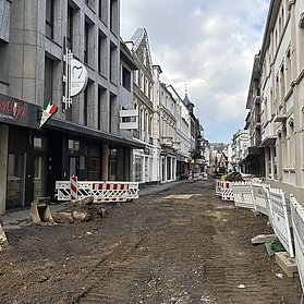 Erde und Dreck bilden den Boden, umgeben von Bauzäunen.