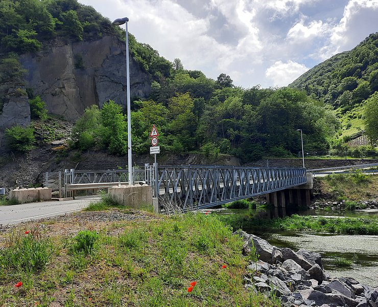 Brücke über der Ahr umgeben von Wald und Felsen.