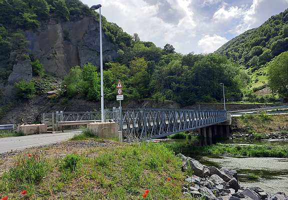 Brücke über der Ahr umgeben von Wald und Felsen.