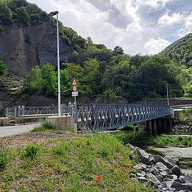 Brücke über der Ahr umgeben von Wald und Felsen.