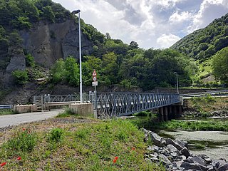 Brücke über der Ahr umgeben von Wald und Felsen.
