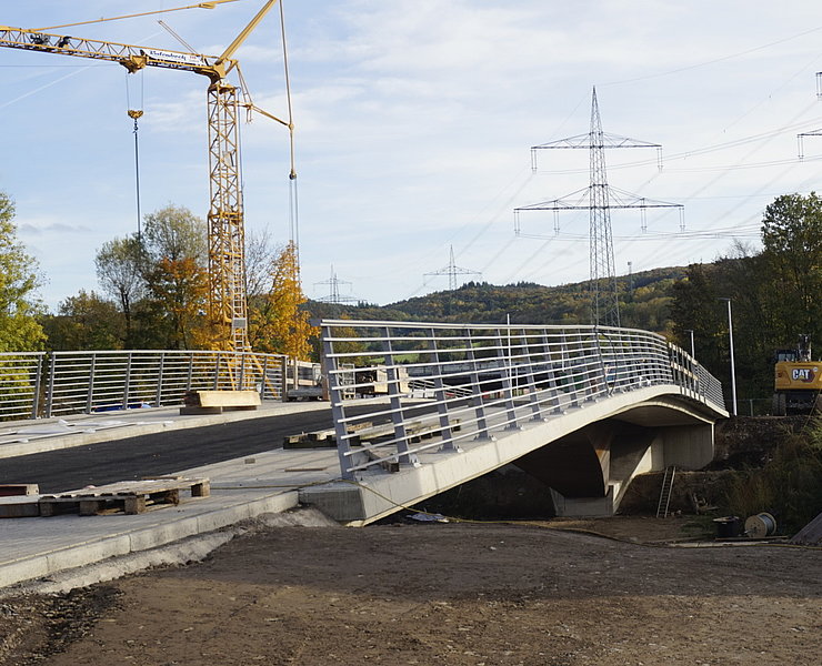 Heppinger Brücke im Stadtteil Heppingen: Moderne fertiggestellte Brücke mit Stahlgeländer und herbstlicher Kulisse.
