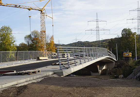 Heppinger Brücke im Stadtteil Heppingen: Moderne fertiggestellte Brücke mit Stahlgeländer und herbstlicher Kulisse.