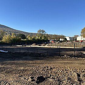 Erde und Aufbau-Arbeiten für die künftigen Tennisplätze bei blauem Himmel