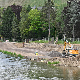 Baustelle an der Carl-von-Ehrenwall-Allee in Ahrweiler mit Bagger am Flussufer.