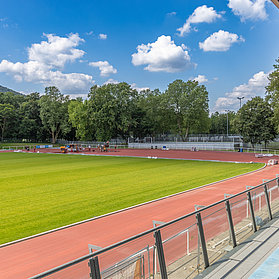 Apollinarisstadion in Bad Neuenahr: Modernes Sportstadion im Bau mit Laufbahn und Spielfeld in naturnaher Umgebung.