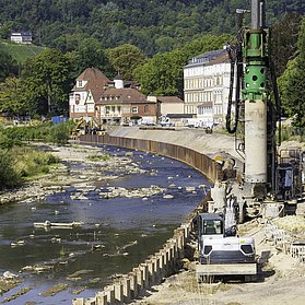 Baustelle an der Carl-von-Ehrenwall-Allee in Ahrweiler mit schweren Geräten am Flussufer im Baugebiet.