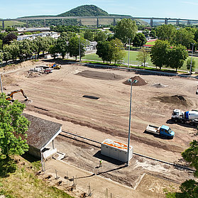 Baustelle des Apollinarisstadions im Stadtteil Bad Neuenahr mit Blick auf die umliegende Landschaft und Brücke.