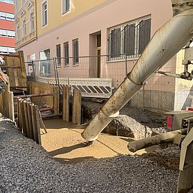 Großgerät füllt mithilfe eines Rohrs den Flüssigboden.