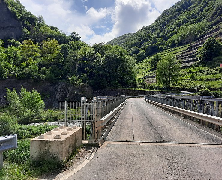 Brücke über der Ahr umgeben von Wald und Weinbergen.