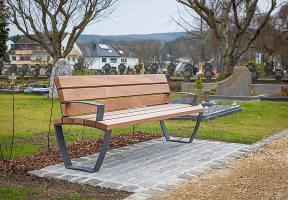 Moderne Sitzbank auf dem Ahrtor-Friedhof in Ahrweiler, eingebettet in eine ruhige, gepflegte Friedhofsumgebung.