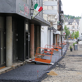 Behelfsmäßige Übergänge zwischen Straße und Geschäften ermöglichen den Betrieb während den Aspahltierungsarbeiten.