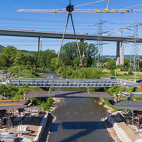 Einhub der Heppinger Brücke mit zwei Baukränen und grüner Landschaft.