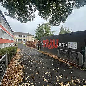 Aloisius-Grundschule in Ahrweiler mit Baustellenzaun und herbstlichem Laub auf dem Schulweg im Stadtteil Ahrweiler.