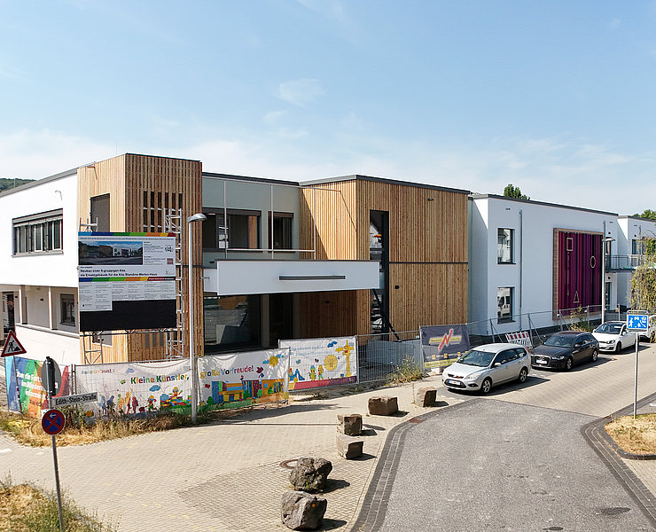 Die Holzfassade am Eingang ist befindet sich links und rechts vom Eingang.