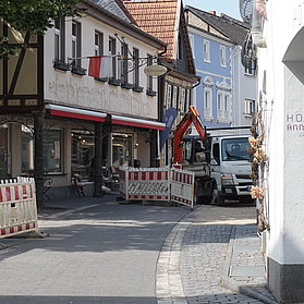 Blick auf Bagger und Transporter am Ende der Straße.