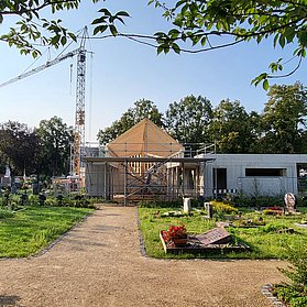 Aussegnungshalle am Friedhof Ahrweiler im Stadtteil Ahrweiler in Bauphase, eingebettet in grüne Grabfelder.