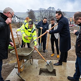Beteiligte der Grundsteinlegung mit Spaten.