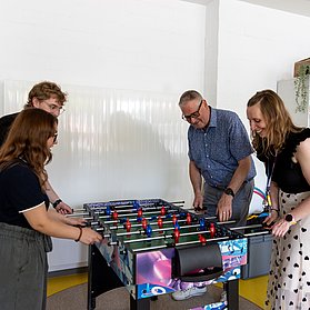 Leitung der OKUJA und Peter Diewald spielen Tischfußball in der Erich Kästner - Realschule Plus im Stadtteil Bad Neuenahr