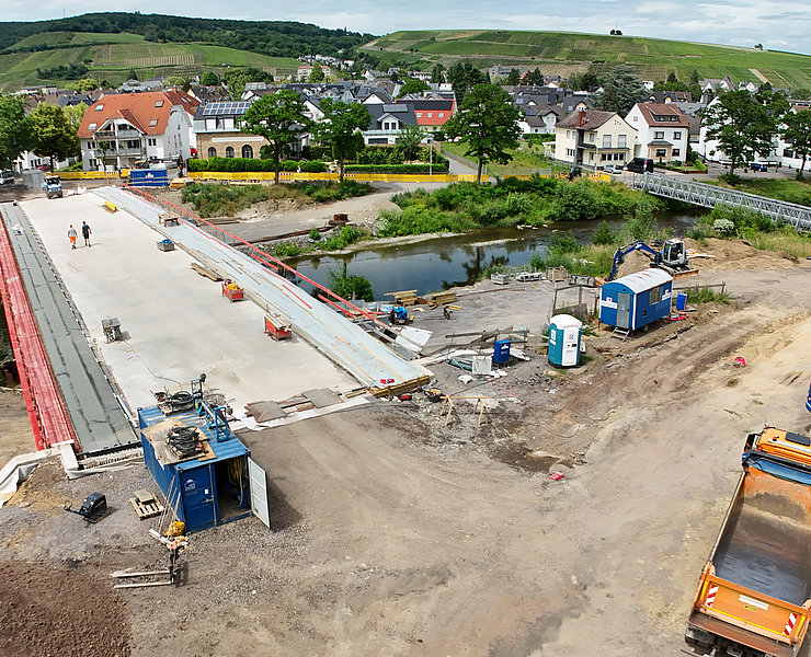 Baufortschritt der Bachemer Brücke im Stadtteil Bachem mit Baugeräten und Fluss im Ahrtal.