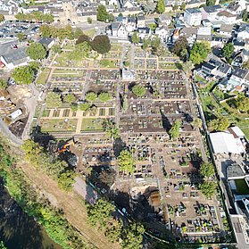 Luftaufnahme des Ahrtor-Friedhofs in Ahrweiler, umgeben von Wohnhäusern und nahe dem Flussufer.