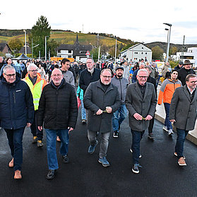 Vertreter der Stadt und Bürgerinnen und Bürger laufen erstmals über die neue Heppinger Brücke.