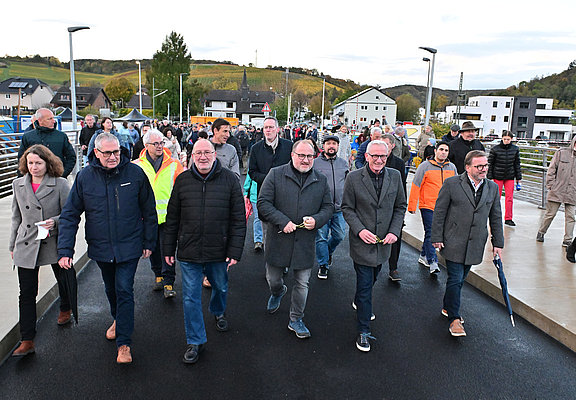 Vertreter der Stadt und Bürgerinnen und Bürger laufen erstmals über die neue Heppinger Brücke.