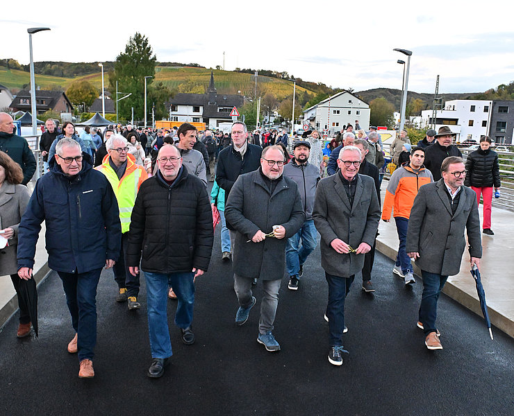 Vertreter der Stadt und Bürgerinnen und Bürger laufen erstmals über die neue Heppinger Brücke.