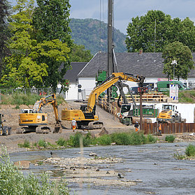 Baustelle der Carl-von-Ehrenwall-Allee im Stadtteil Ahrweiler mit Baggern und Fluss im Vordergrund.
