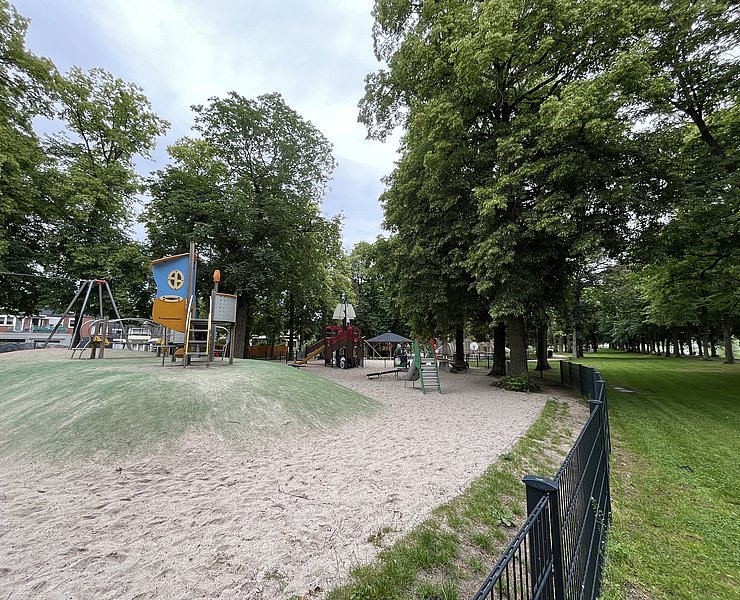 Klettergerüste und Schaukeln umgeben von Sand.