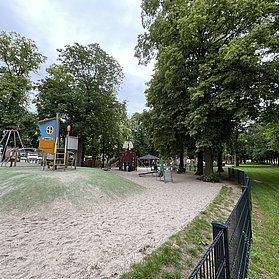 Klettergerüste und Schaukeln umgeben von Sand.