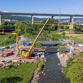 Luftaufnahme vom Einhub der Heppinger Brücke mit drei Baukränen und grüner Landschaft.