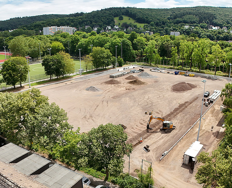 Apollinarisstadion im Bau im Stadtteil Bad Neuenahr mit Baggern und Baustoffen umgeben von grüner Landschaft.