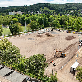 Apollinarisstadion im Bau im Stadtteil Bad Neuenahr mit Baggern und Baustoffen umgeben von grüner Landschaft.