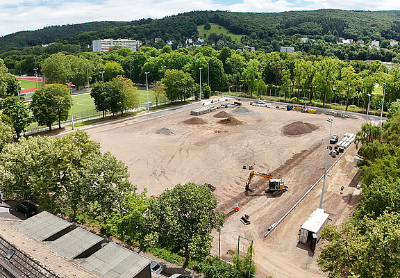 Apollinarisstadion im Bau im Stadtteil Bad Neuenahr mit Baggern und Baustoffen umgeben von grüner Landschaft.