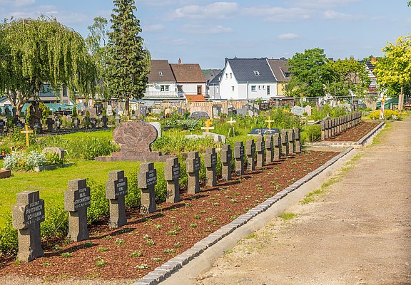 Ahrtor-Friedhof Ahrweiler im Stadtteil Ahrweiler mit Reihen von Grabkreuzen und gepflegtem Friedhof unter blauem Himmel.