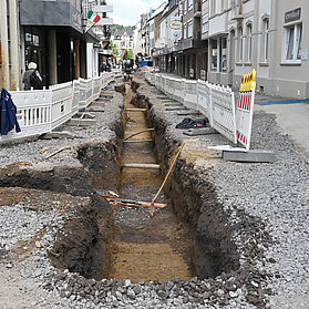 Graben entlang der Poststraße umgeben von Bauzäunen.