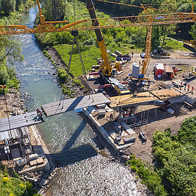 Luftaufnahme vom Einhub der Heppinger Brücke mit drei Baukränen und grüner Landschaft.
