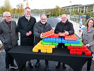 Vertreter der Stadt feiern die Eröffnung mit bunten Bausteinen.